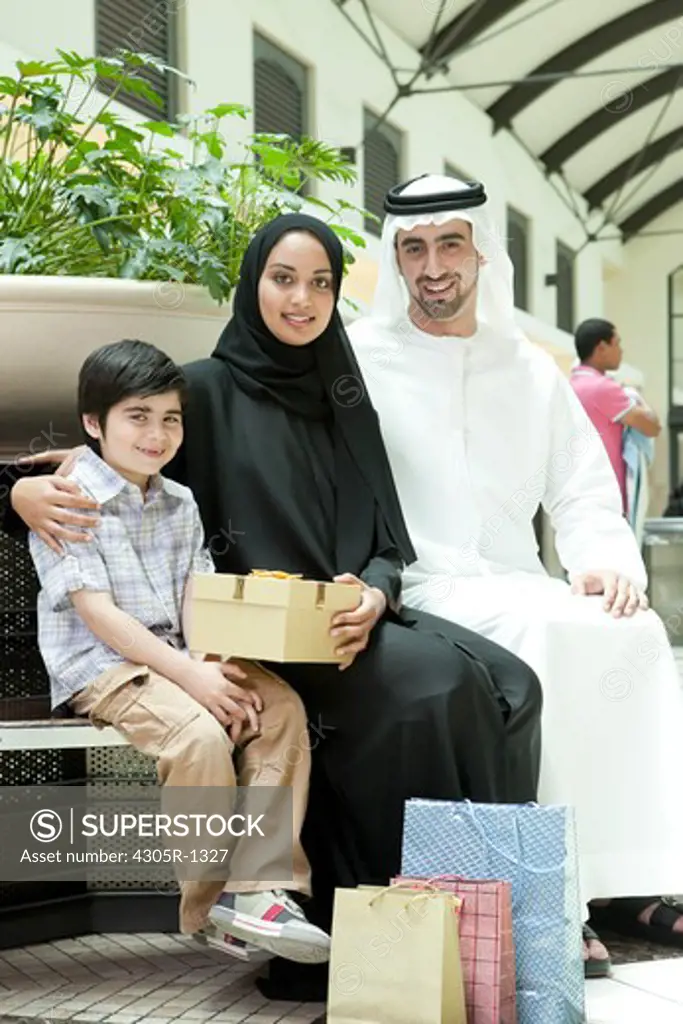 Portrait of arab family with gifts sitting at the shopping mall.