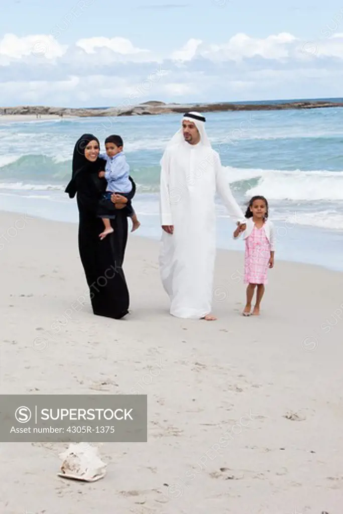 Arab family walking together at the beach.