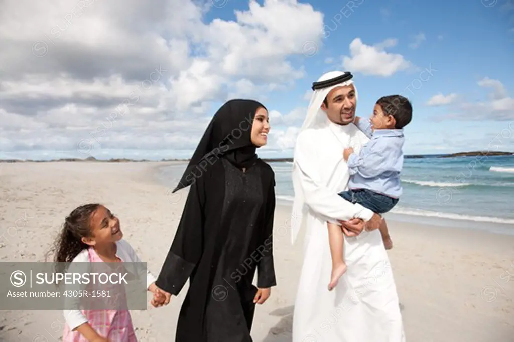 Arab family walking together at the beach.