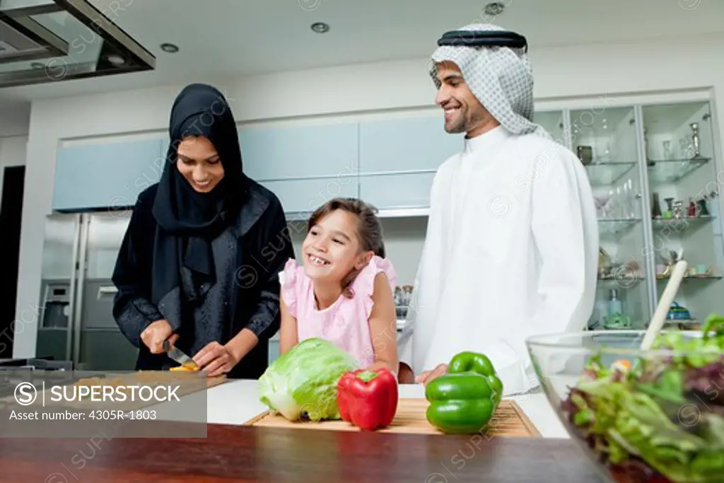 Arab family cooking together in the kitchen.