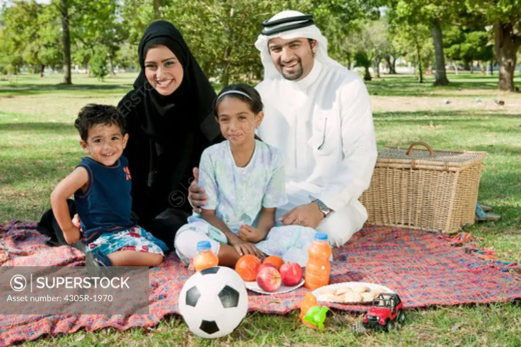 Portrait of arab family in the park, smiling.