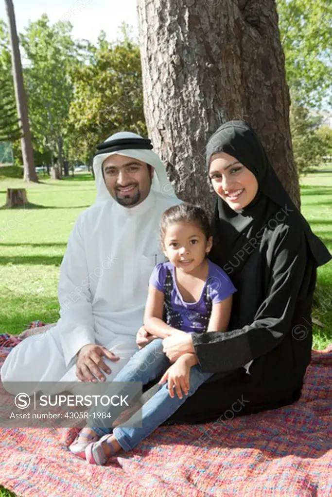Portrait of arab family sitting in the park.