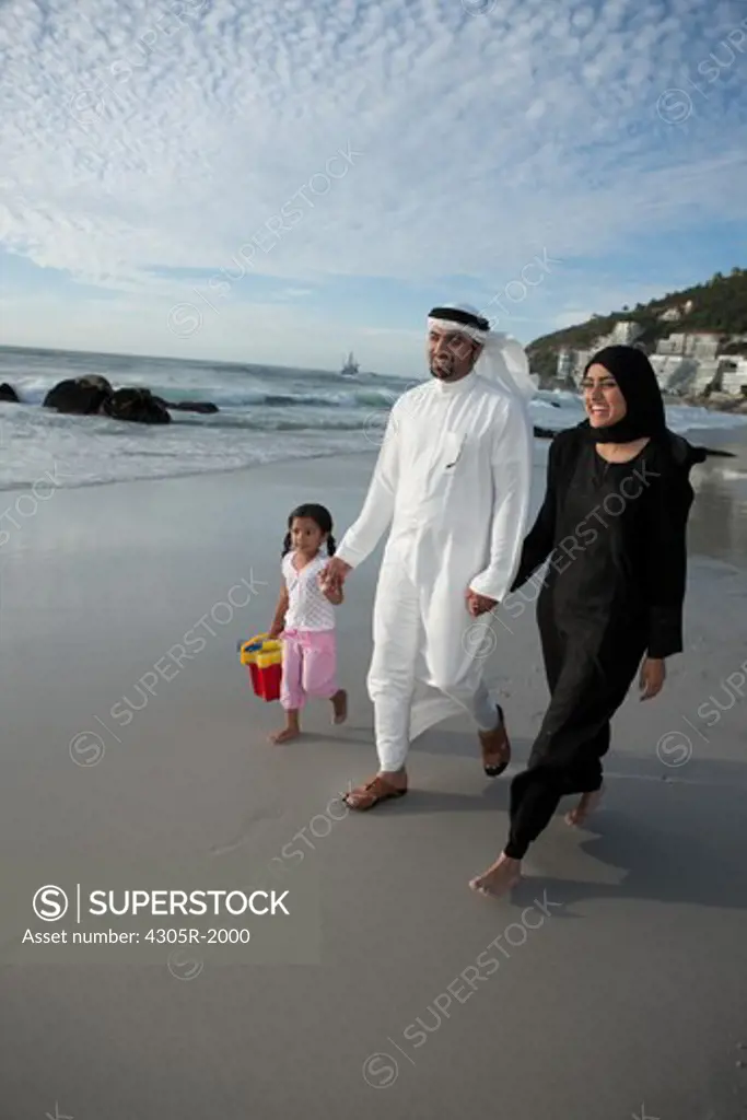 Arab family walking by the beach.