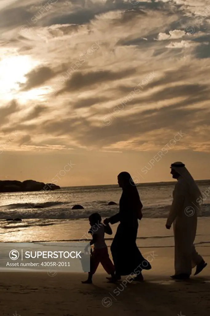 Arab family walking by the beach.