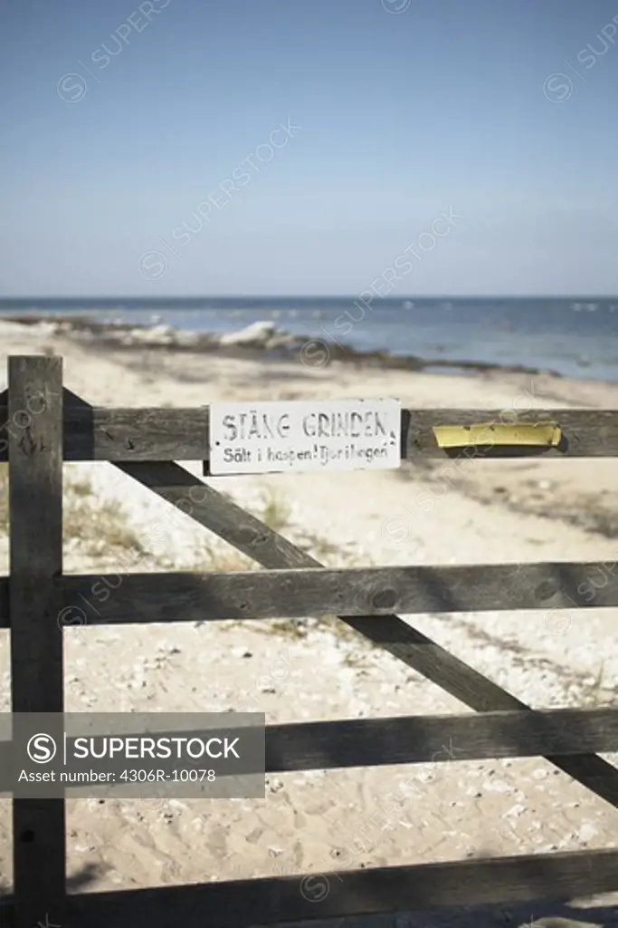 A closed gate on a beach.