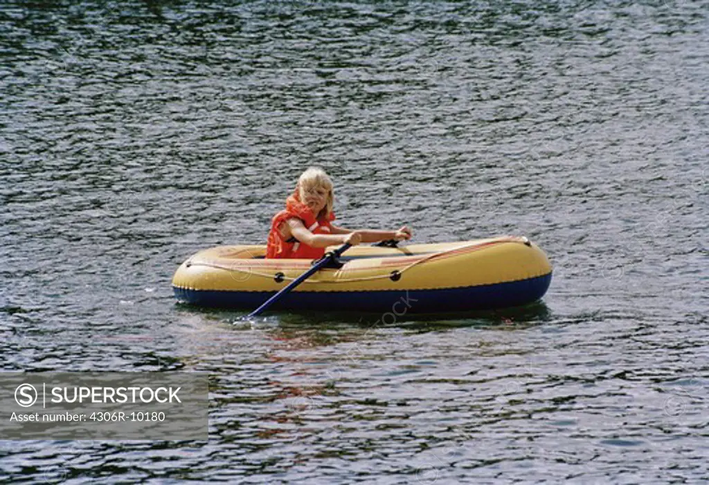 Girl rowing dinghy Stockholm archipelago, Sweden.