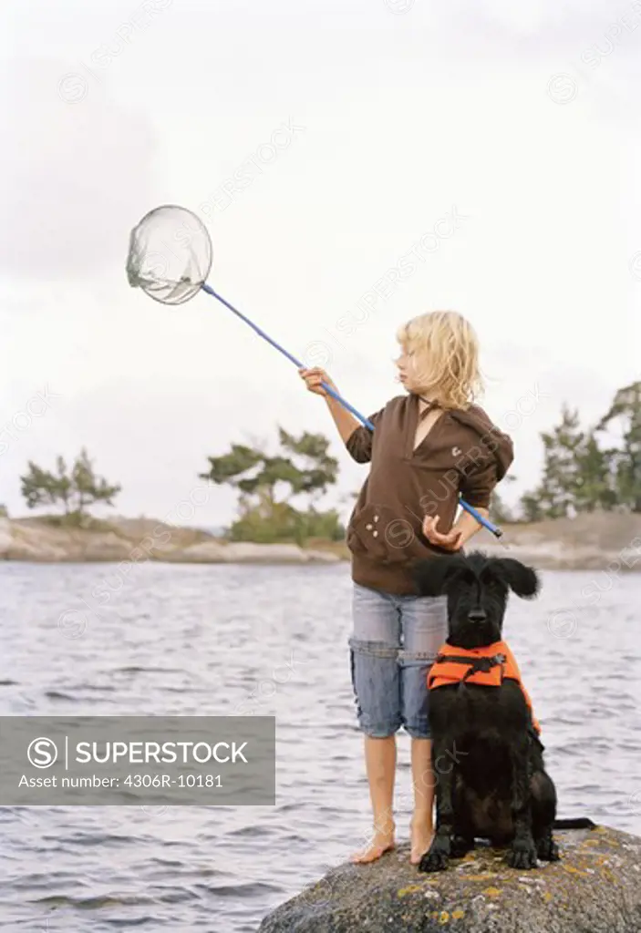 A girl and a dog with a life jacket.