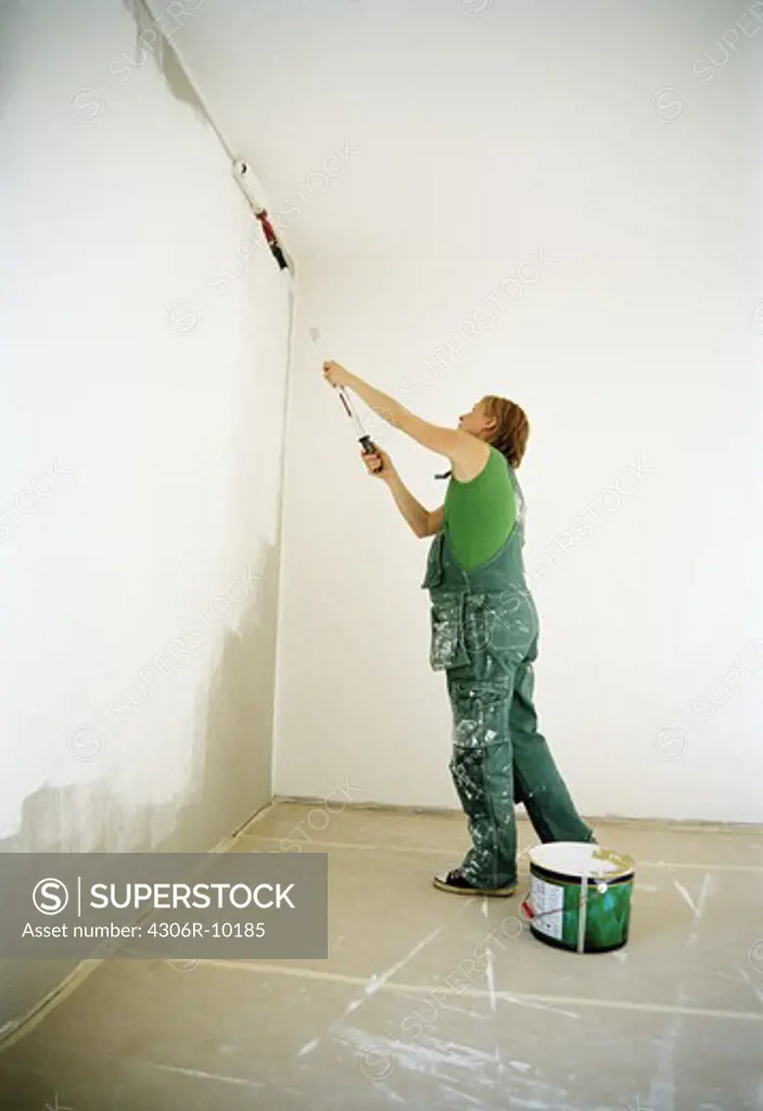 A woman painting a wall.