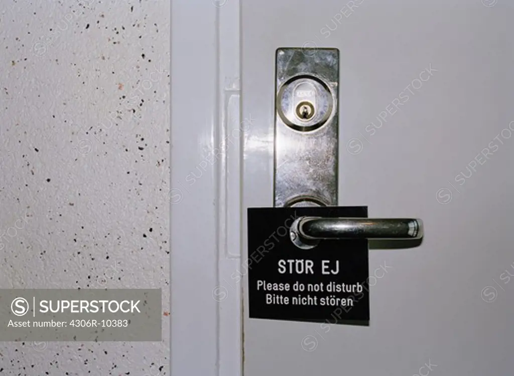 A sign on a door handle.