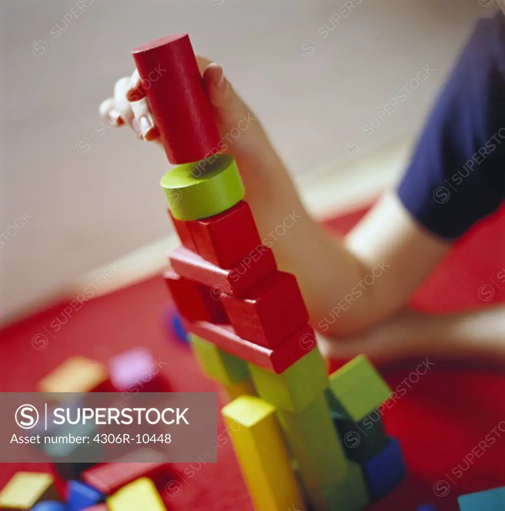 Child building a tower using toy bricks, Sweden.