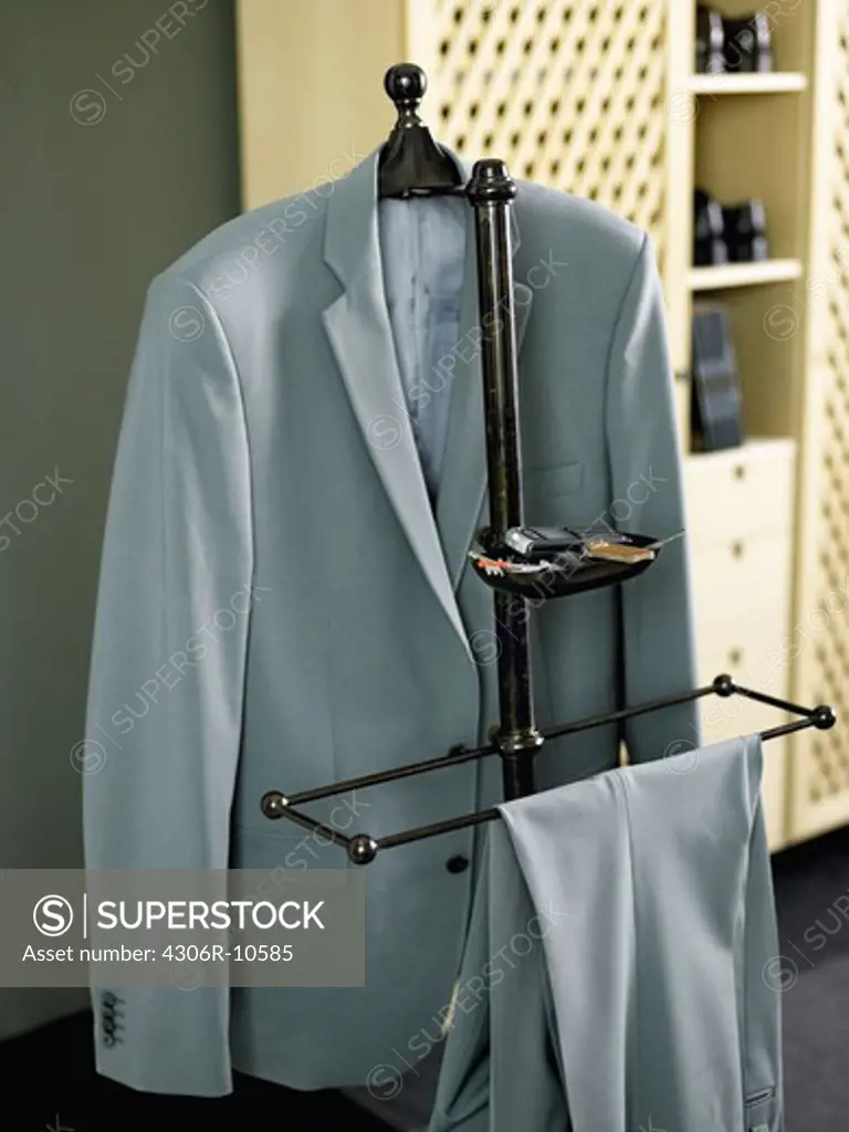 A suit hanging on a hatstand.