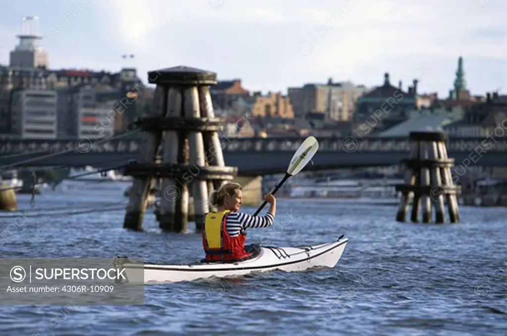 Woman canoeing in Stockholm, Sweden.