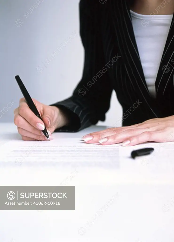 Woman signing a paper, Sweden.