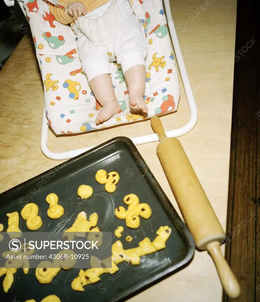 Baking sheet with saffron buns, a rolling pin and a baby, Stockholm, Sweden.
