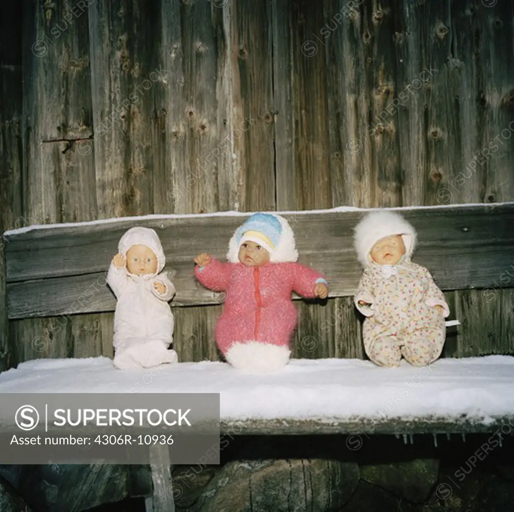 Three dolls sitting on a bench, Roslagen, Sweden.