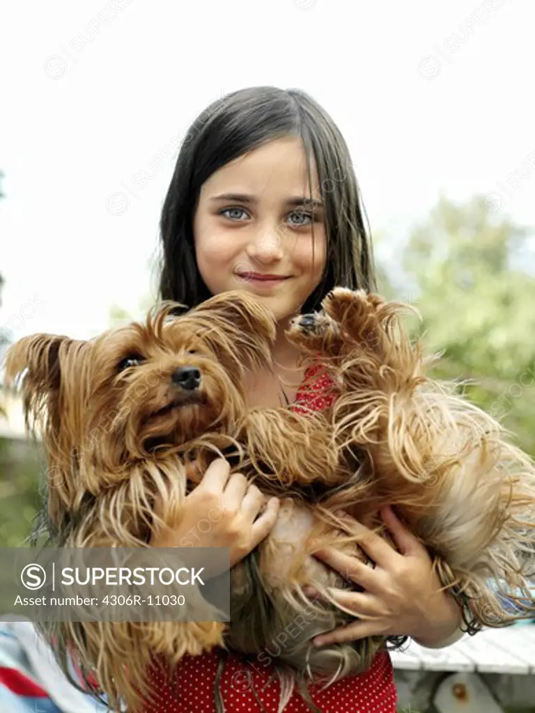 A girl carrying a dog, Sweden.