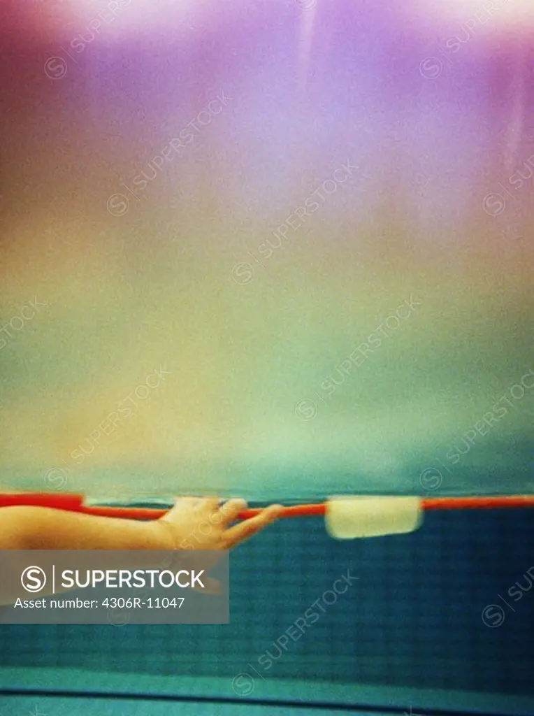 The arm of a person in a swimming pool.