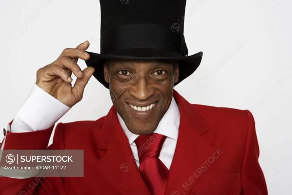 A smiling man wearing a hat and a red suit.