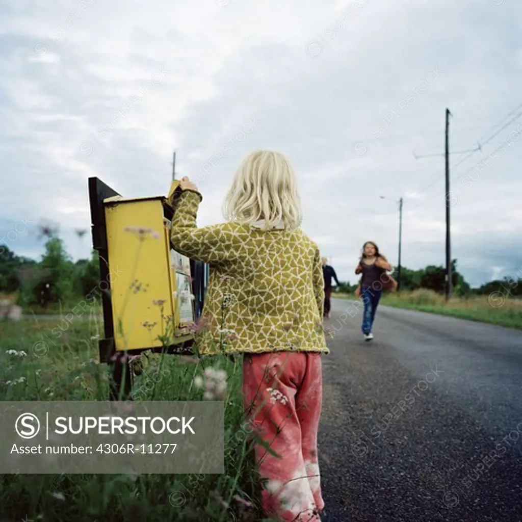 Girl standing by a mail box, Oland, Sweden.