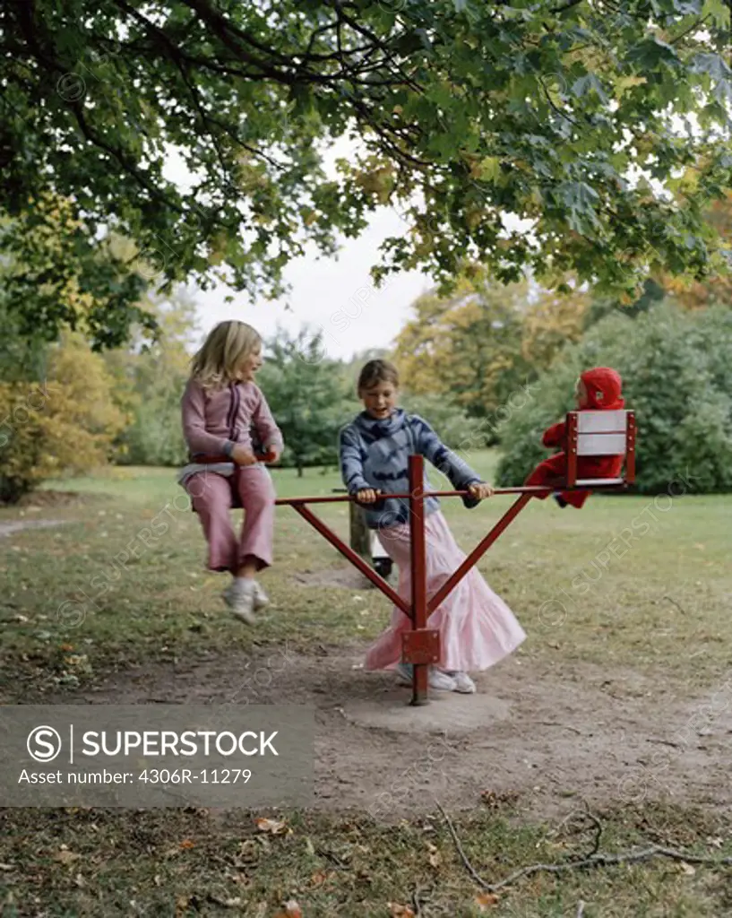 Three girls playing in a playground, Sweden.