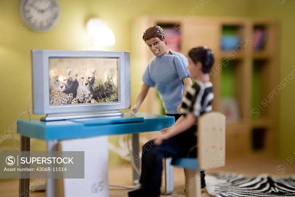 Father and son infront of a computer, dolls in a dollhouse.