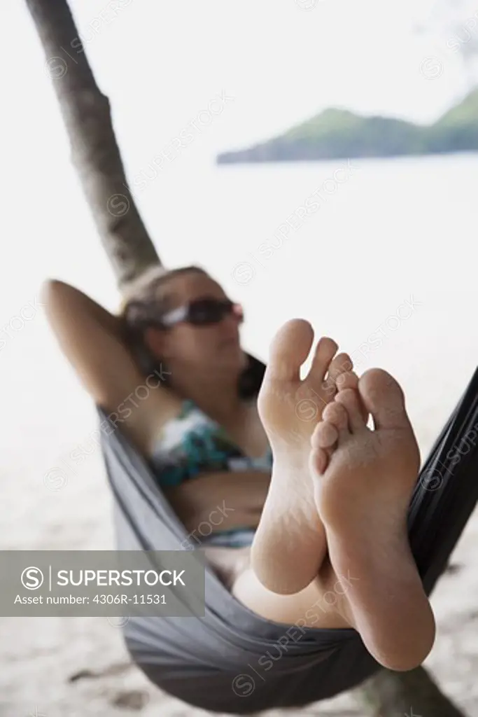 A woman in a hammoc on a beach in Thailand.