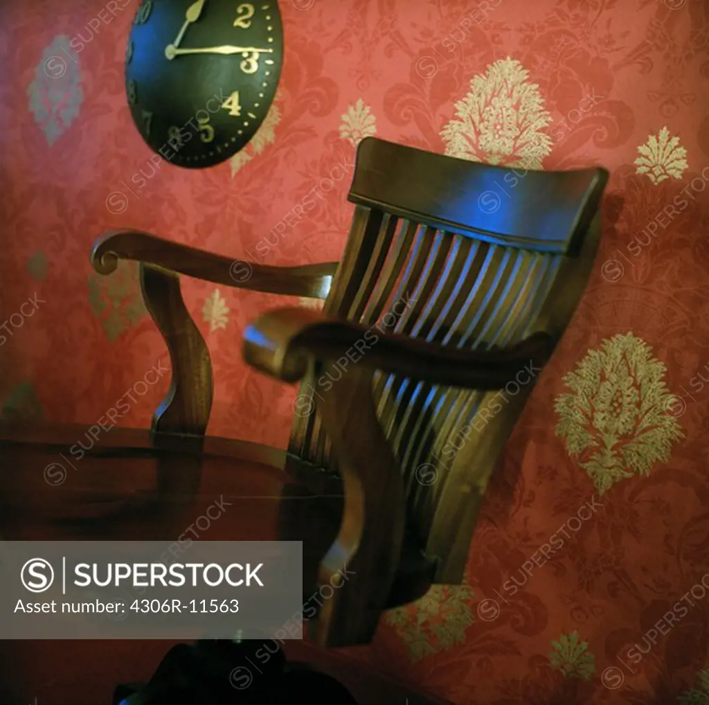 An armchair and and red wallpaper.