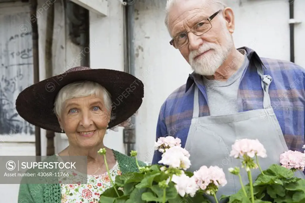 An elderly scandinavian couple holding a flowerbox, Sweden.