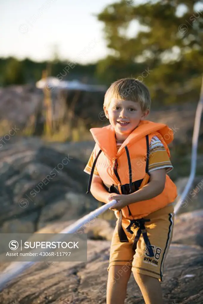 A Scandinavian boy holding on to a rope''s end, Sweden.