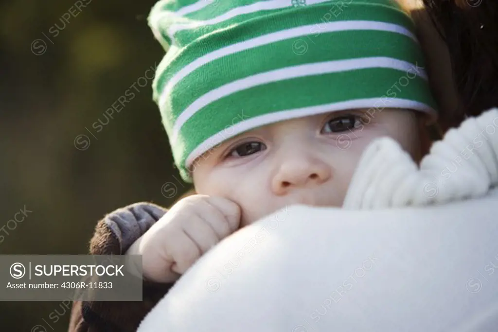 A little baby wearing a green hat, Sweden.