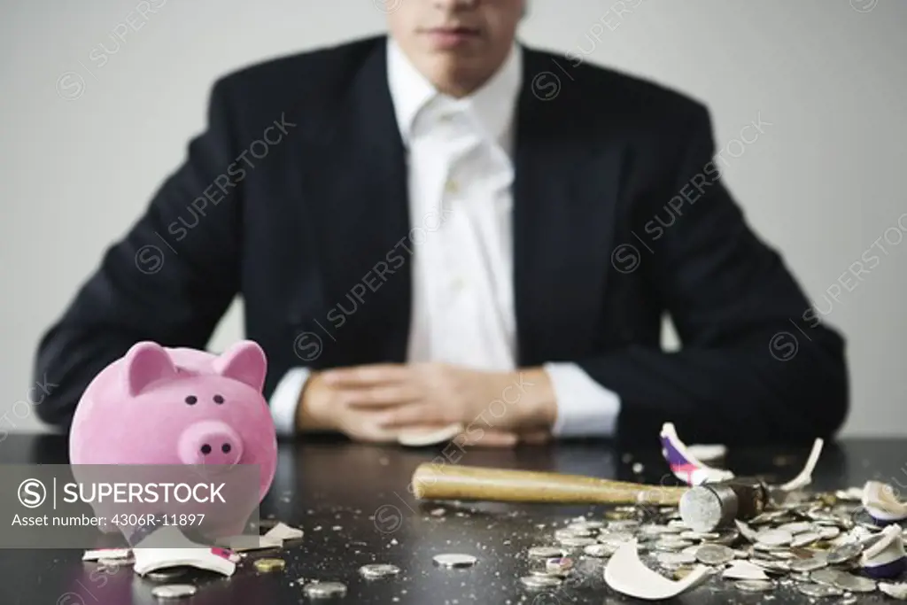 A man with an unbroken and a broken piggy bank.