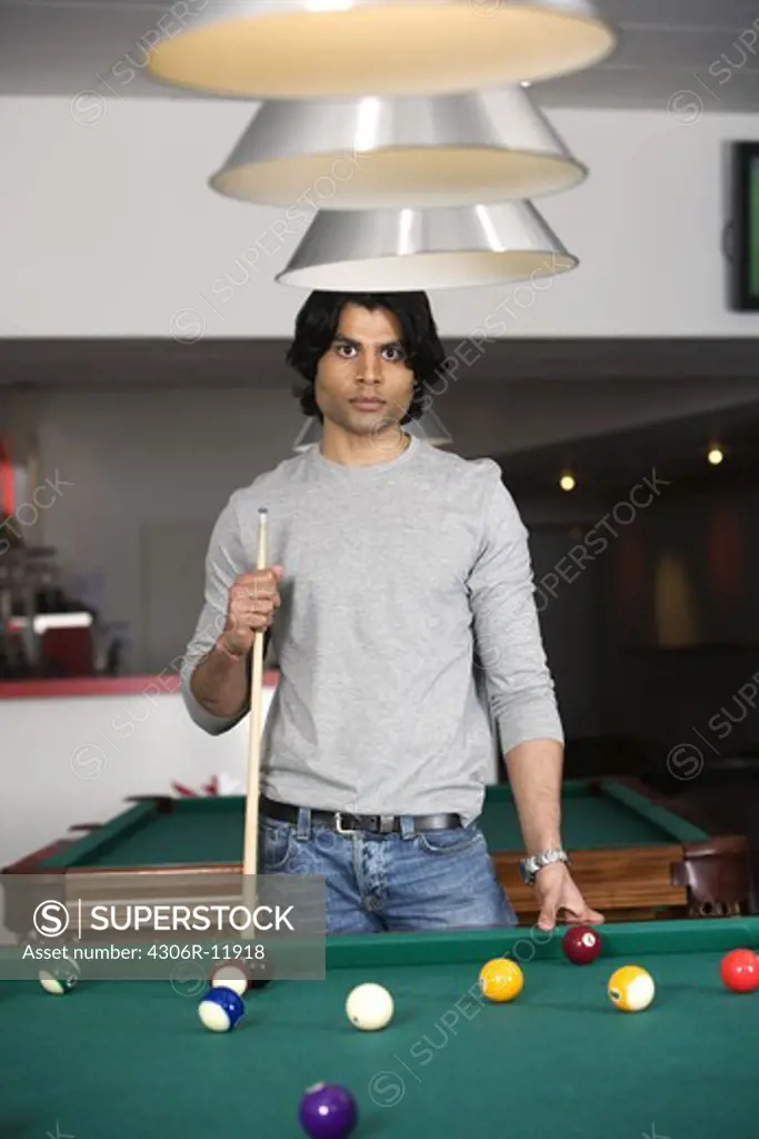 Man standing by a pool table.