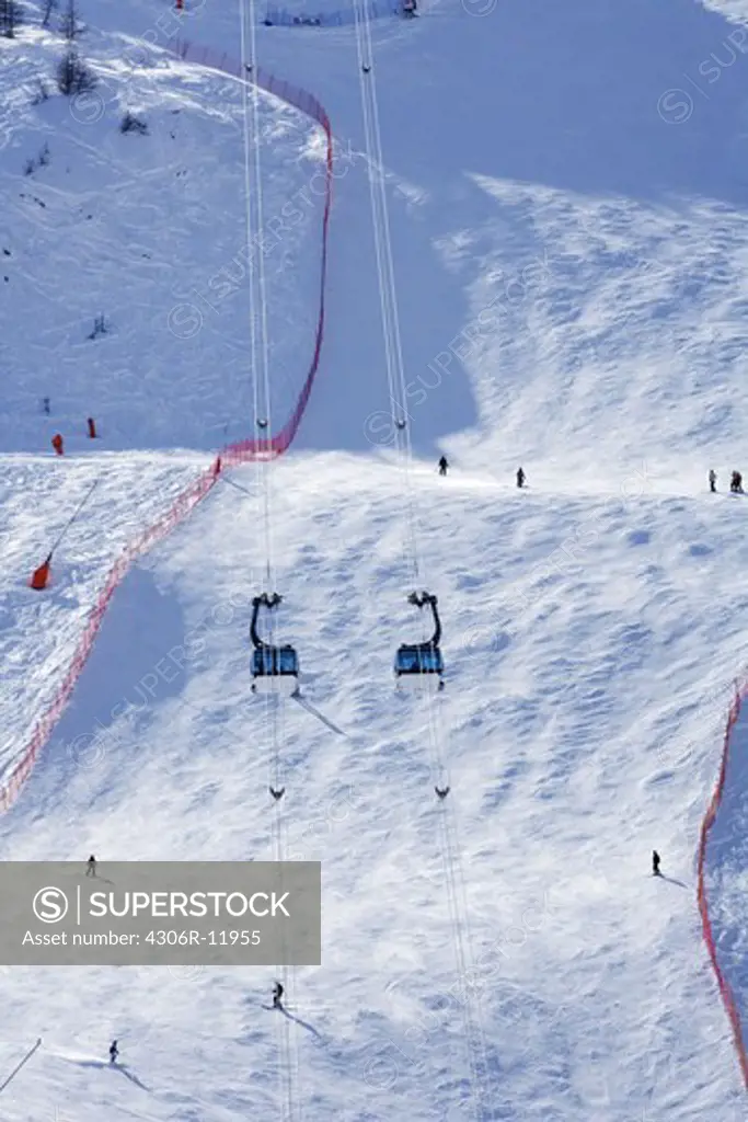 Ski-lift suspended by cable in snow covered mountain
