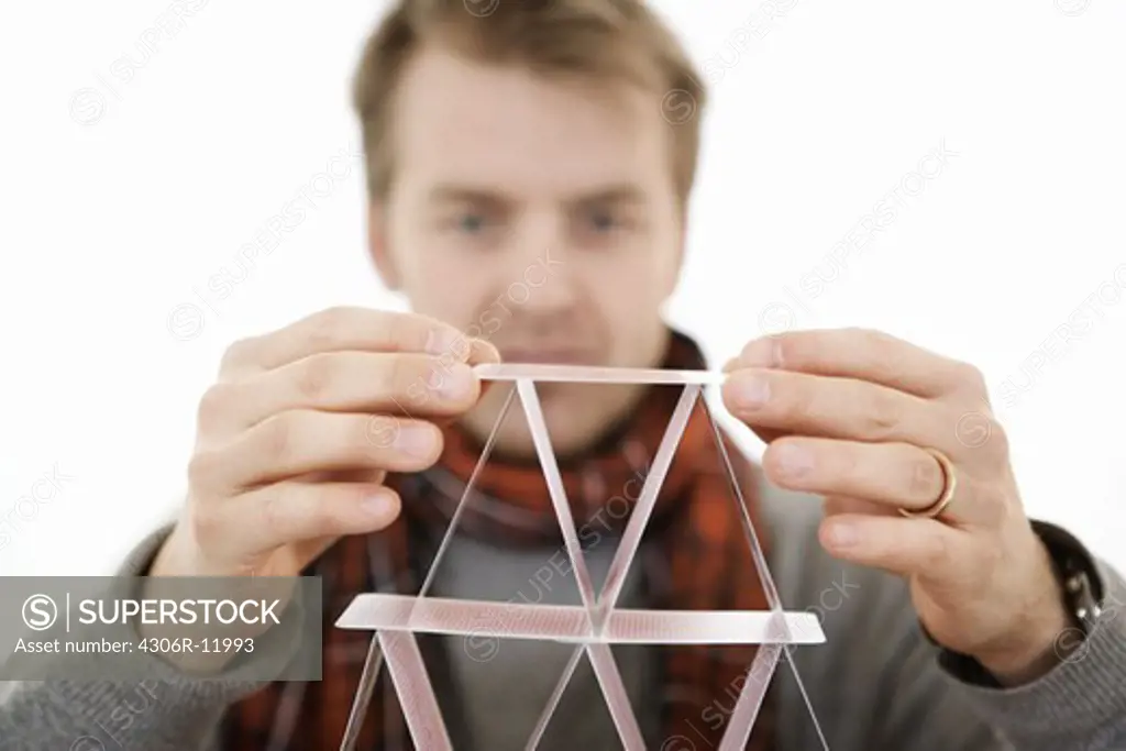 Man building a house of cards.