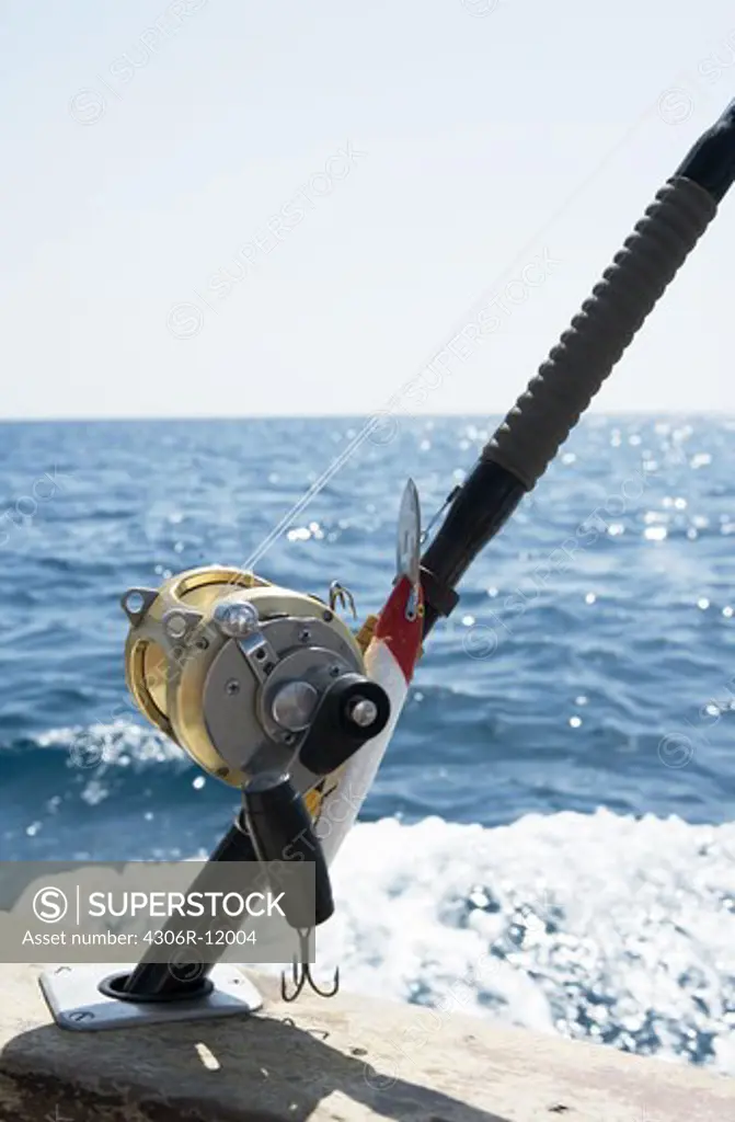 Close-up fishing rods on railings of boat in sea