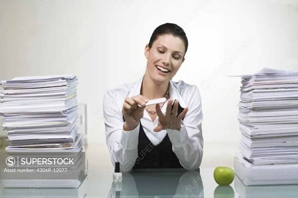 A woman in an office doing her nails.