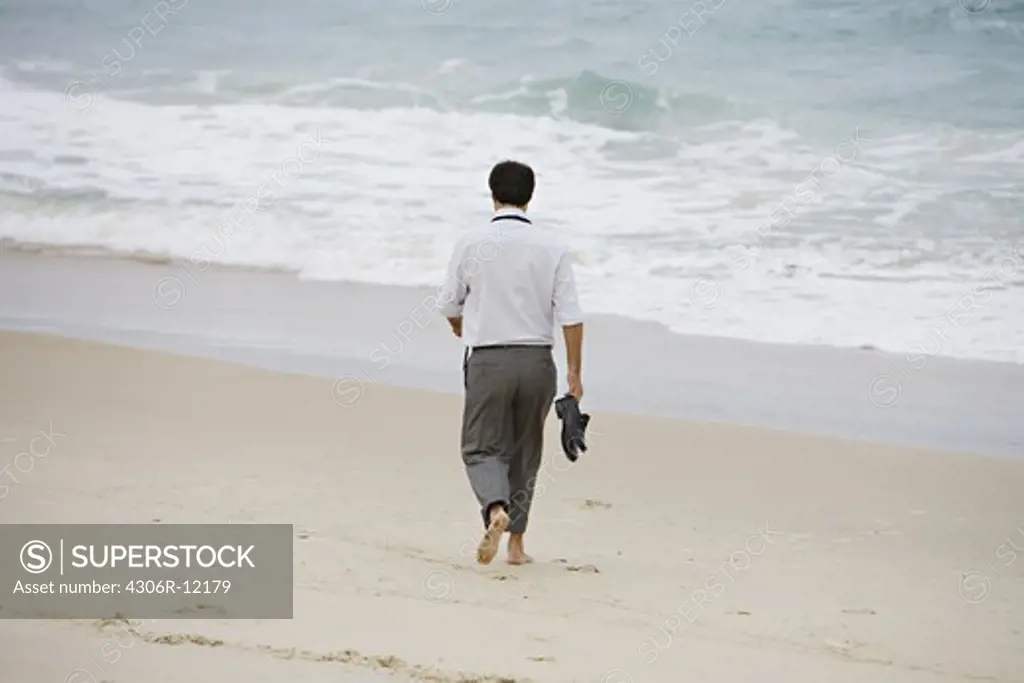 A Scandinavian man walking on the beach, Brazil.