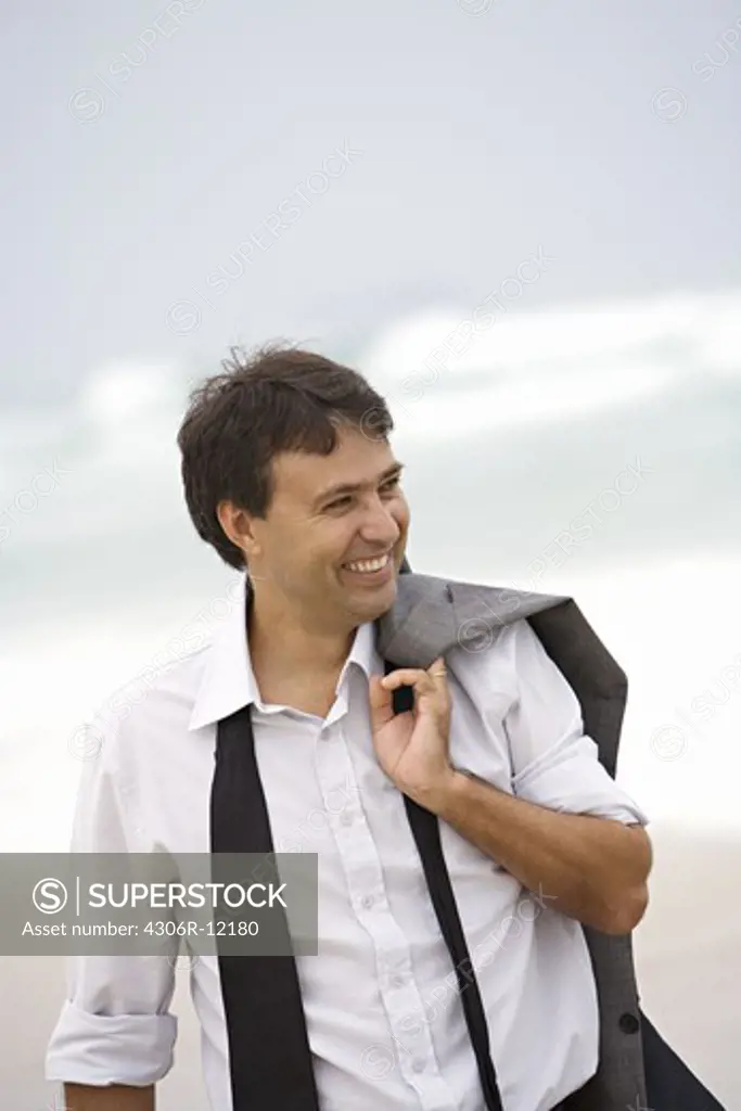 A smiling man walking on the beach, Brazil.