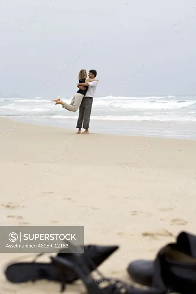 A middle-aged couple embracing on the beach, Brazil.