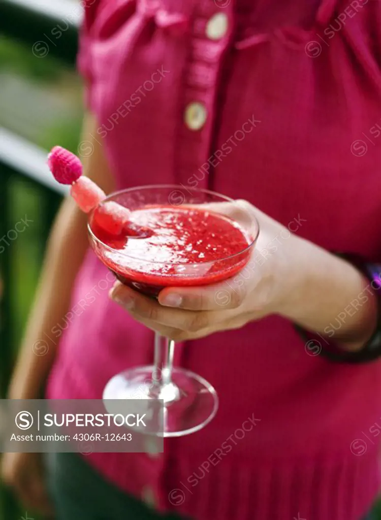 A woman holding a drink, Sweden.
