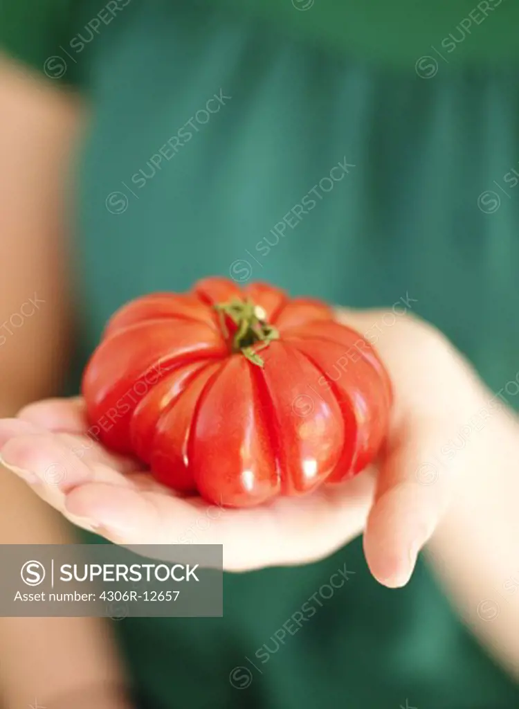 A woman holding tomatoes, Sweden.