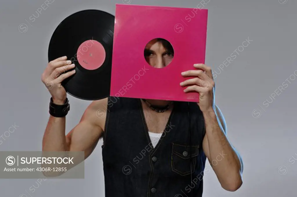 A young man with earphones holding a LP, Sweden.