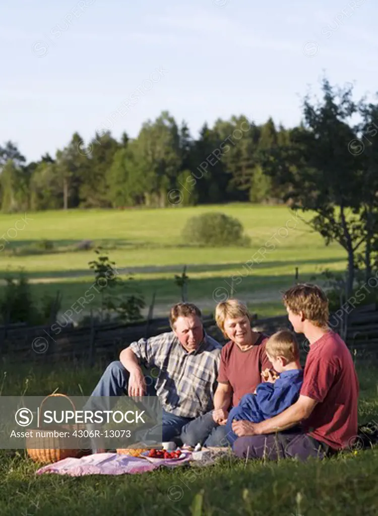 A farmer family taking a break in the grass, Sweden.