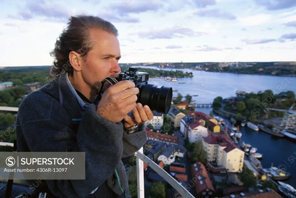 A man with a camera with a view over Stockholm, Sweden.