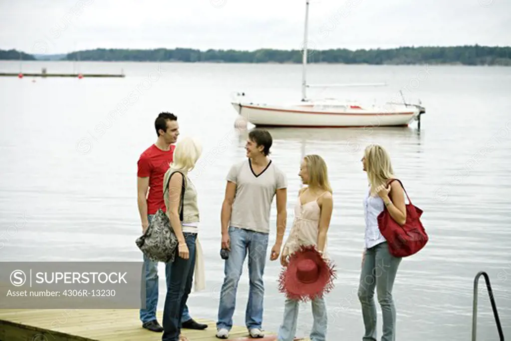 Five friends standing on a jetty, Ljustero, Stockholm archipelago, Sweden.