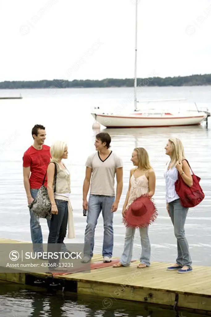 Five friends standing on a jetty, Ljustero, Stockholm archipelago, Sweden.