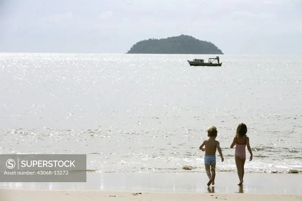Two Scandinavian children playing on the beach, Brazil.