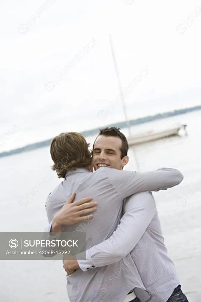 Two male friends embracing, Sweden.