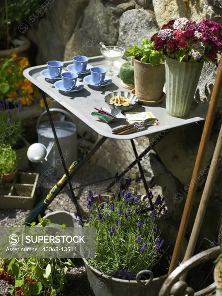 An outdoor table in a   flowering garden, Sweden.