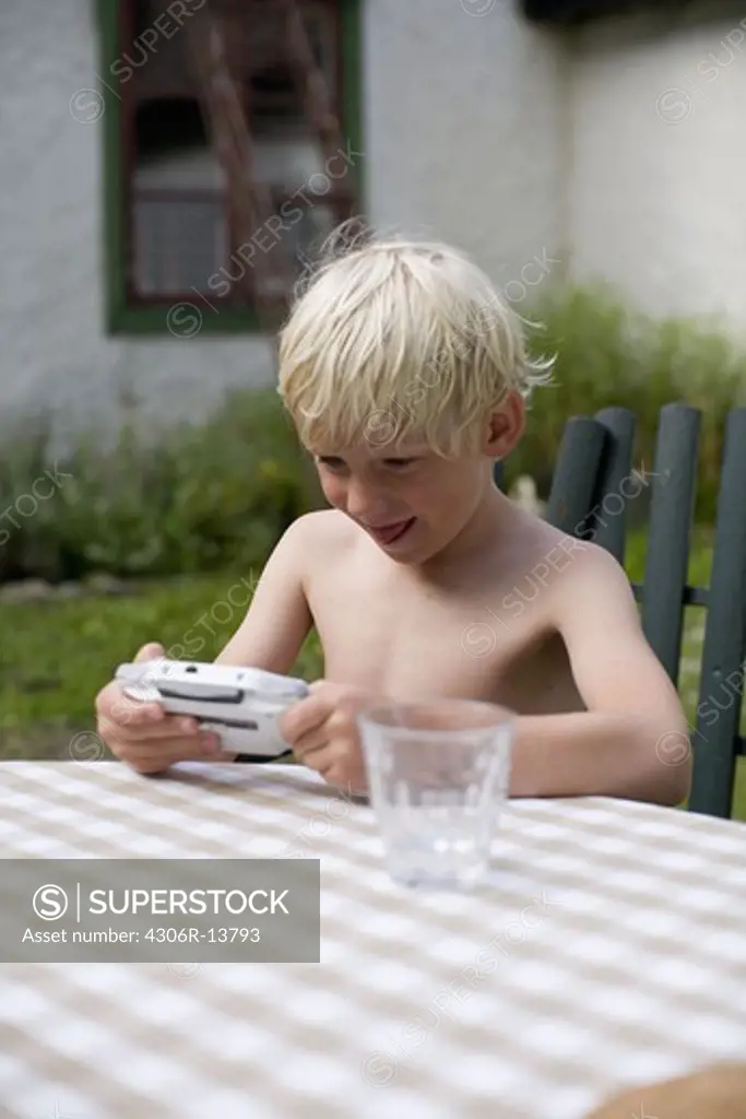 A boy using a gameboy, Gotland, Sweden.